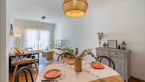 A dining area with a round table, orange plates, and a woven centerpiece.