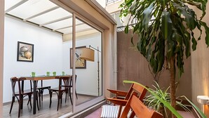 Un coin repas avec une table et des chaises, une grande fenêtre et une plante en pot.