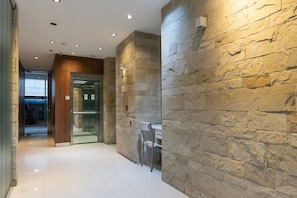 Experience the sleek, modern interior with a polished floor and textured stone wall.