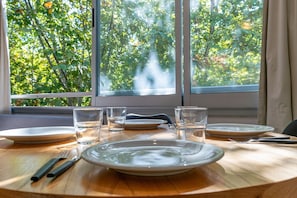 Enjoy a serene meal with a view of lush greenery from this dining table for four.