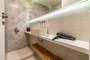 A modern bathroom with a shower, a vanity with a mirror, and a hairdryer on the counter. - Spacious apartment in Palermo (caba)