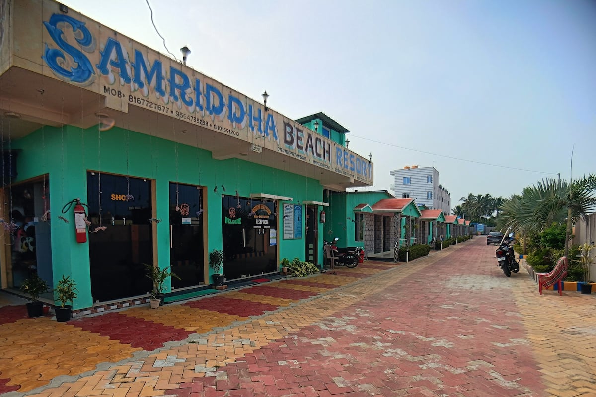 A beach resort with a reception area, a parking area, and a paved walkway.
