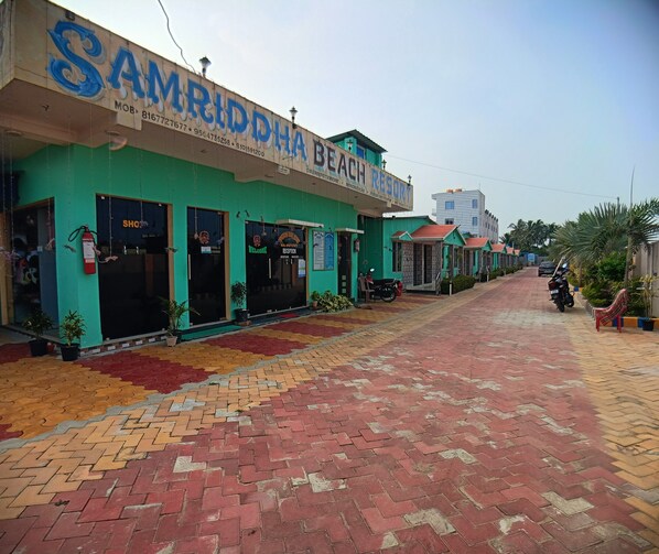 A beach resort with a reception area, a parking area, and a paved walkway. - SAMRIDDHA BEACH RESORT (Kanthi)