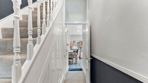Ein Flur mit einer Treppe, die zu einer Küche führt.