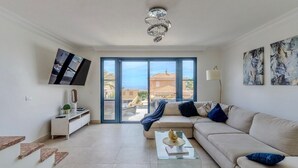 A modern living room with a sofa, coffee table, and a TV mounted on the wall. - Charming Villa Mirador del Duque (Costa Adeje)