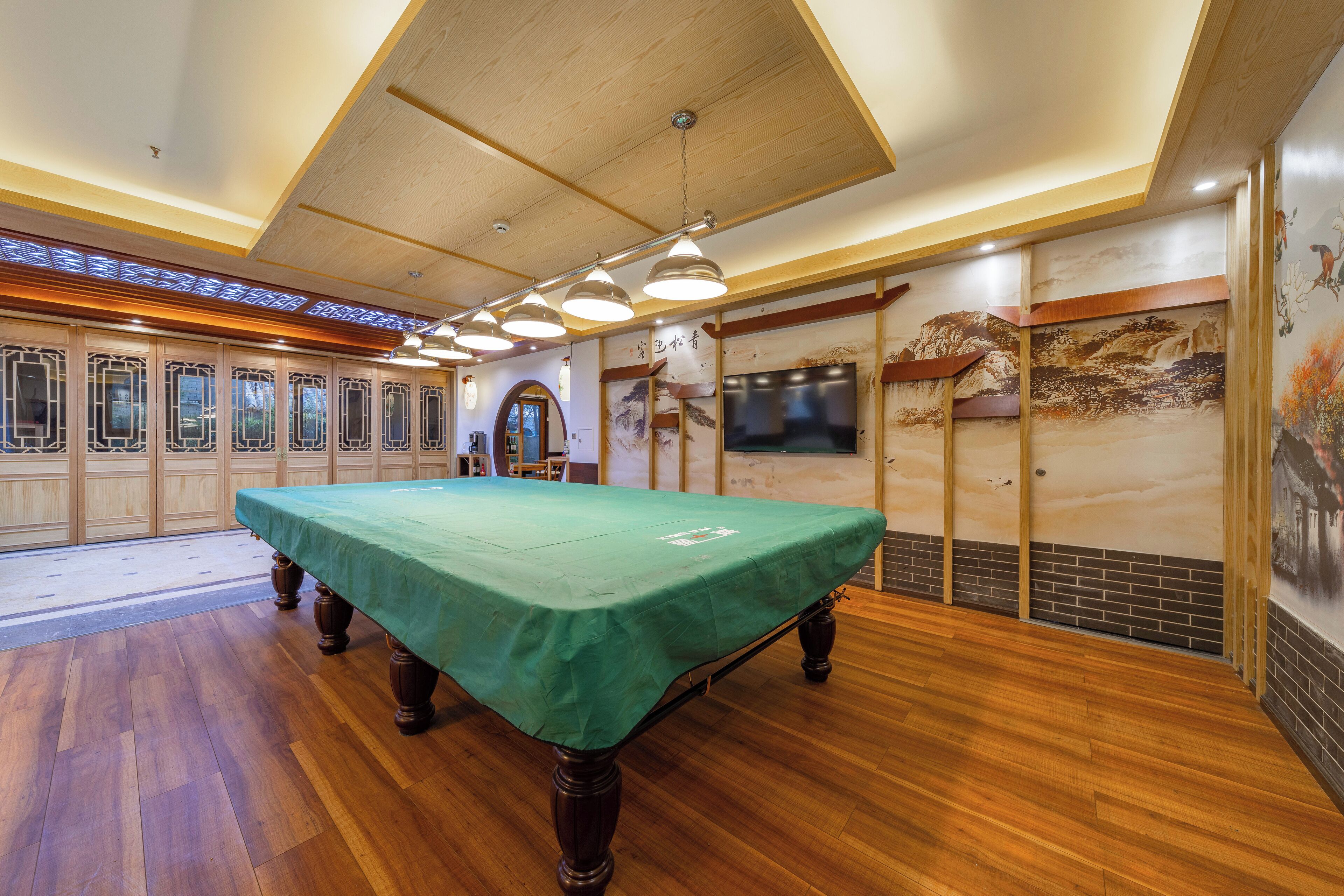 Une pièce dotée d’une table de billard, d’un parquet et d’une décoration de style traditionnel.
