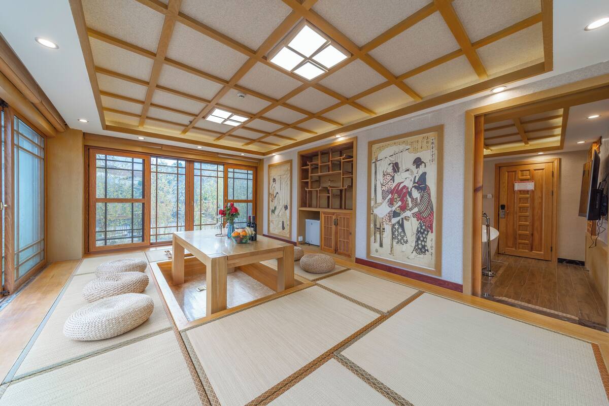 A traditional Japanese room with tatami flooring, a wooden table, and sliding doors.