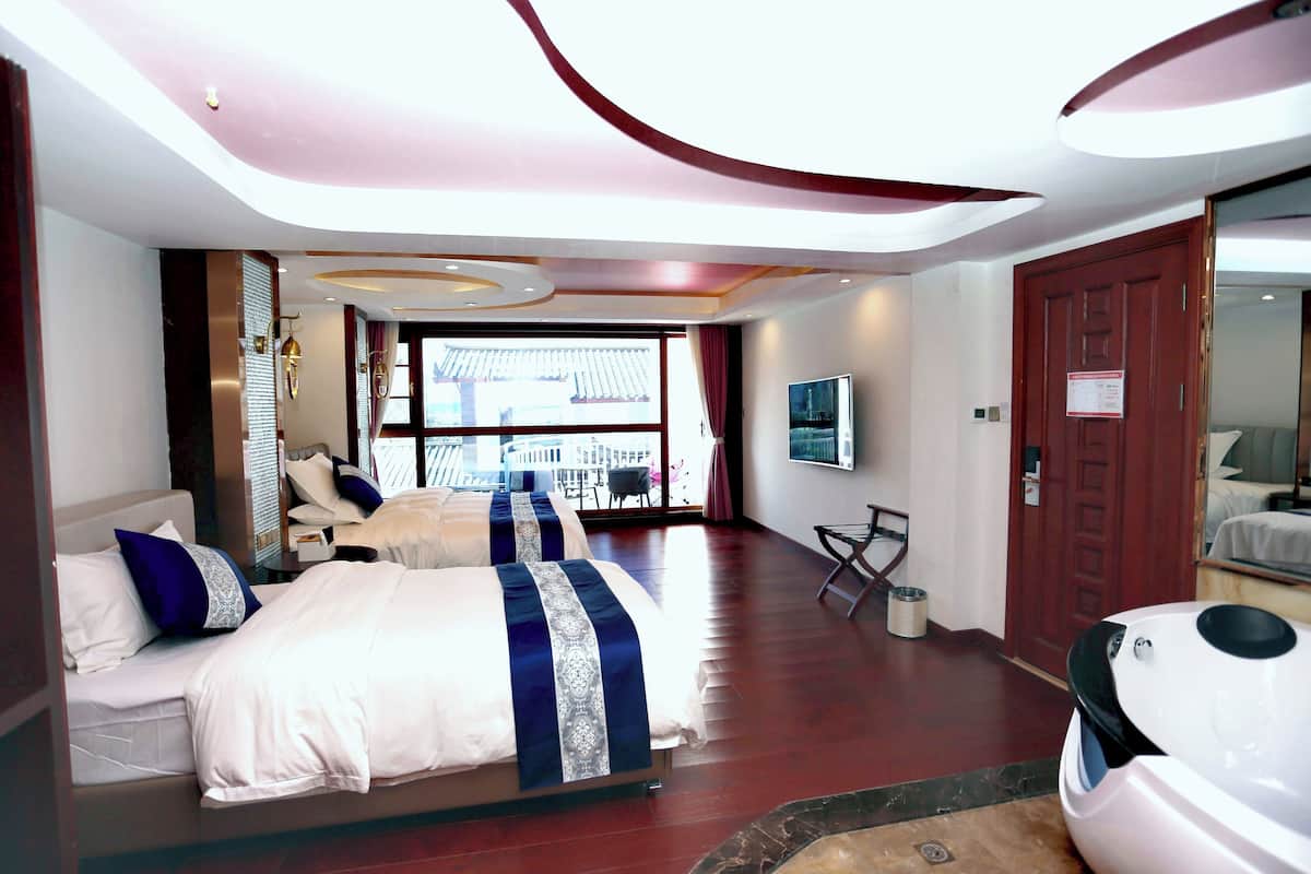 A hotel room with two beds, a large window, a balcony, and a modern ceiling design.