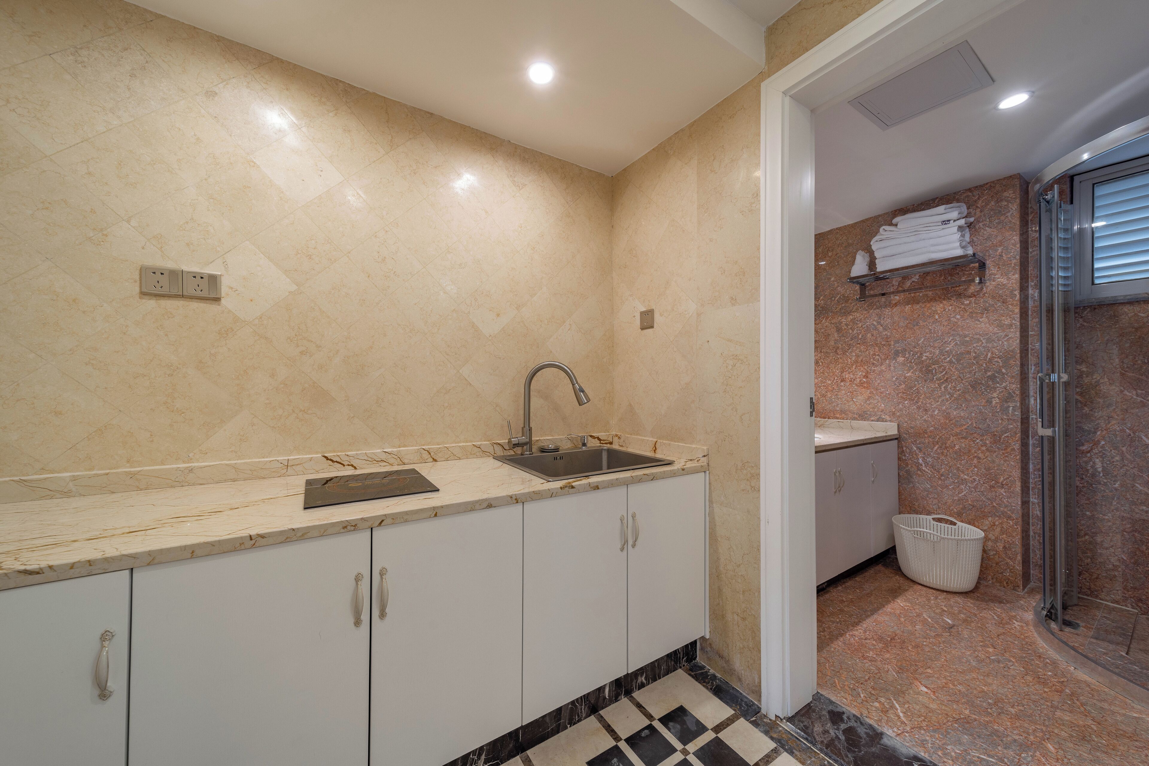 A modern bathroom with a sink, mirror, and shower area.