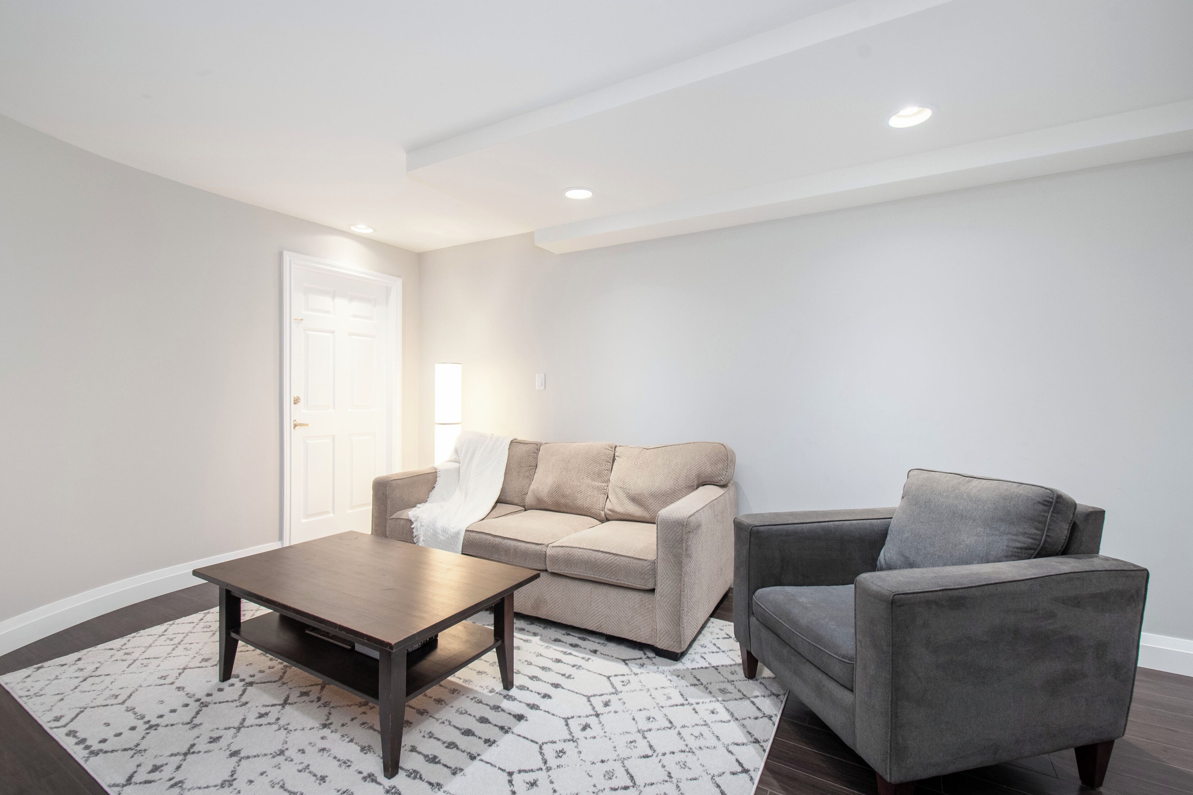 Un salon moderne avec un canapé, un fauteuil et une table basse.