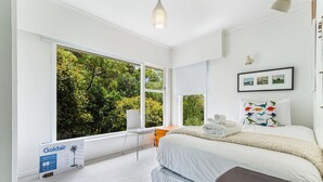 A bedroom with a large window, a bed, a bedside table, and a chair. - Spacious 3Br Mission Bay Home With Parking! (Auckland)