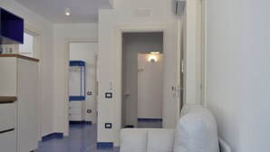 A hotel corridor with a seating area, a bathroom with a shower, and a door leading to another room. - The Bell Tower Clock vacation home (Minori)
