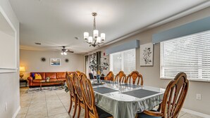 A dining area with a table set for six, surrounded by wooden chairs with cushioned seats. - 10 Mi to Adventure Island: Home w/ Fenced Yard! (Lutz)