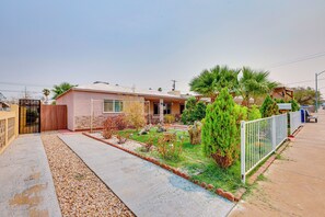 A residential property with a paved driveway, a small garden with various plants, and a wooden fence. - Pet-Friendly Home Near Downtown Henderson (Henderson)