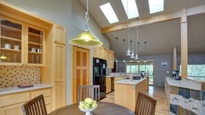 Una cocina moderna con armarios de madera, una mesa de comedor con sillas y una isla central.