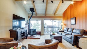 A cozy living room with a fireplace, leather sofa, and a television. - Walk to Ski Lift: Mtn-View Condo in Mammoth Lakes (Mammoth Lakes)