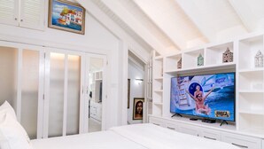 A hotel room with a large bed, a television on the wall, and a wardrobe with mirrored doors. - Choose To Be Happy @ The Seville #E3 [2-Bedroom] (Kingston)