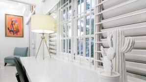 A modern dining area with a white table, a lamp, and a cactus decoration. - Choose To Be Happy @ The Seville #E3 [2-Bedroom] (Kingston)