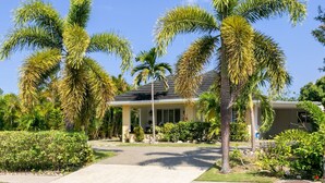 A house with a driveway, palm trees, and a well-maintained lawn. - CTBH @ The Palms at Richmond Estates - Villa #170 [3-Bedroom w/ Pool] (Richmond Estates)