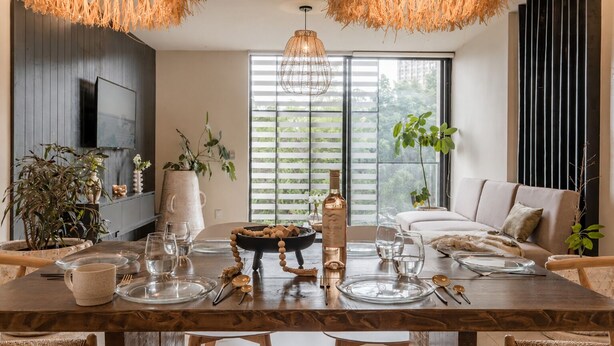 A dining area with a wooden table set for four, surrounded by wicker chairs. - Urban minimalist 3 BedRoom / Daily Cleaning (Guadalajara)
