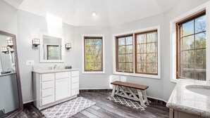 A modern bathroom with a vanity, sink, and bench.