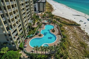 Ein Hotel mit großem Pool, Zugang zum Strand und mehreren Balkonen.
