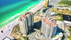 Ein Küstenhotel mit mehreren Hochhäusern, einem Strand und einem Steg.