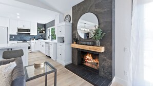 A modern kitchen with white cabinets, a central island, and a built-in microwave.