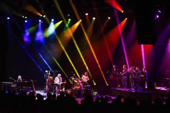 A band performing on a stage with various musical instruments and a keyboard.