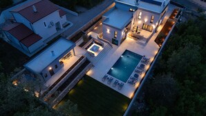 A modern house with a swimming pool, outdoor seating, and a well-lit patio area. - Amazing home in Vrh with sauna (Vrh)