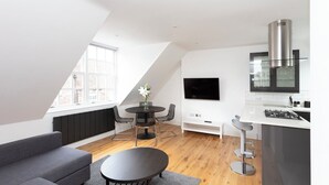A modern loft apartment with a dining area, kitchen, and living space. - Hampden Apartments - The William (Windsor)