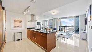 A modern kitchen with a central island, large windows, and a city view.