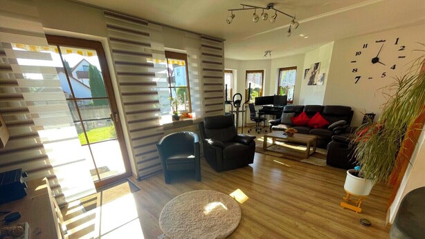Ein modernes Wohnzimmer mit einem Klavier, einer Couch und einem Couchtisch.