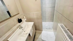 A bathroom with a sink, mirror, towel, and radiator. - Chic one bedroom with parking&terrace (Luxembourg City)