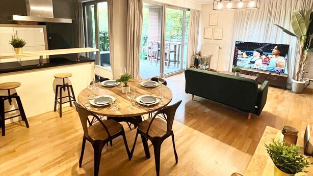 A modern living room with a dining area, a kitchen, and a TV. - Chic one bedroom with parking&terrace (Luxembourg City)