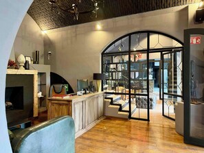 Un intérieur moderne avec une cheminée, un bureau équipé d’un ordinateur et un escalier menant à un niveau supérieur.