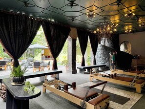 Un intérieur moderne avec une cheminée en pierre, une table de massage et une vue sur l’espace extérieur.