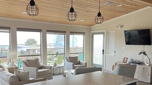Una cucina moderna con una grande isola, elettrodomestici integrati e illuminazione a sospensione.