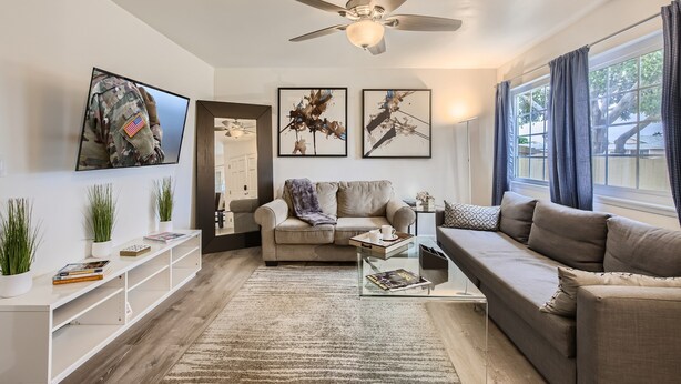 A modern living room with a sofa, coffee table, and artwork on the walls. - NEW - Awesome 6BR - 15 Min To Beach (Oceanside)