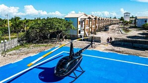 Um helicóptero estacionado em um heliponto azul, com um edifício ao fundo.