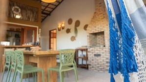 Um restaurante acolhedor com forno de tijolos, móveis de madeira e luminárias pendentes.