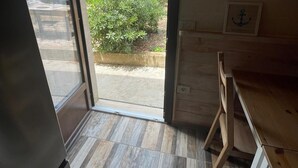 Eine moderne Küche mit großem Fenster, Holzboden und Blick auf einen Garten.