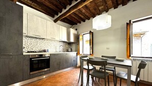 Una cocina con gabinetes grises, salpicadero de azulejos y piso de madera.