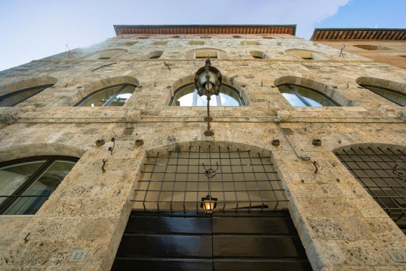 A stone building with arched windows and a central entrance.
