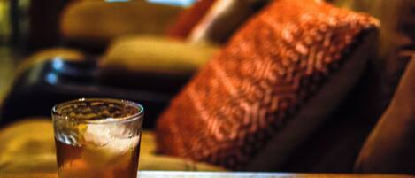 A glass of beer on a wooden table with a magazine.