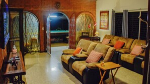 A cozy living room with a sofa set, a small table, and a television.