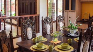 A dining area with a wooden table, chairs, and a ceiling fan.