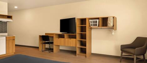 A modern room with a bed, a desk, a chair, a TV, and built-in shelving.