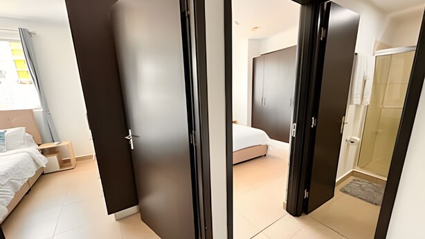 Una habitación de hotel moderna con cama, escritorio y zona de ducha.