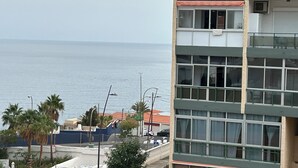 Een gebouw aan de kust met meerdere ramen en balkons met uitzicht op zee.
